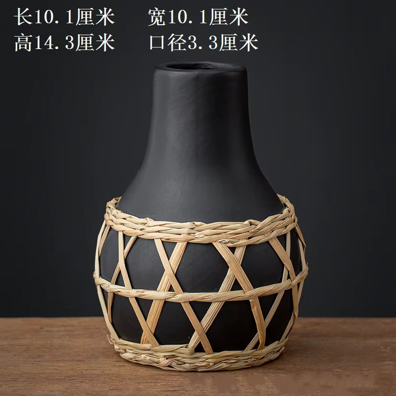 Black vase with woven basket design on a wooden surface and dark background