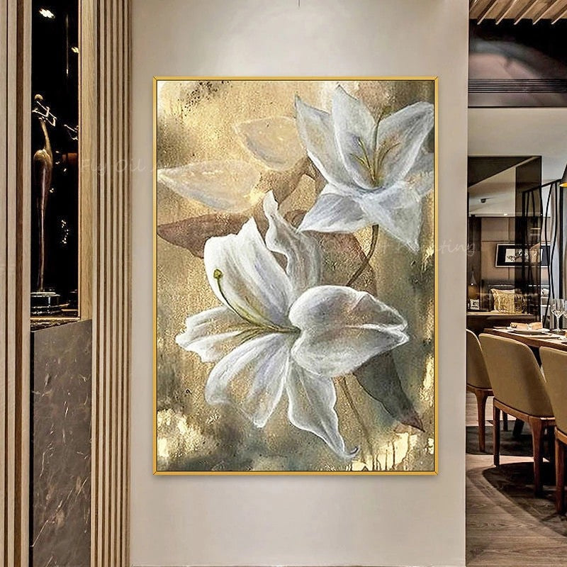 Framed artwork of white flowers on a textured gold background in a room setting.