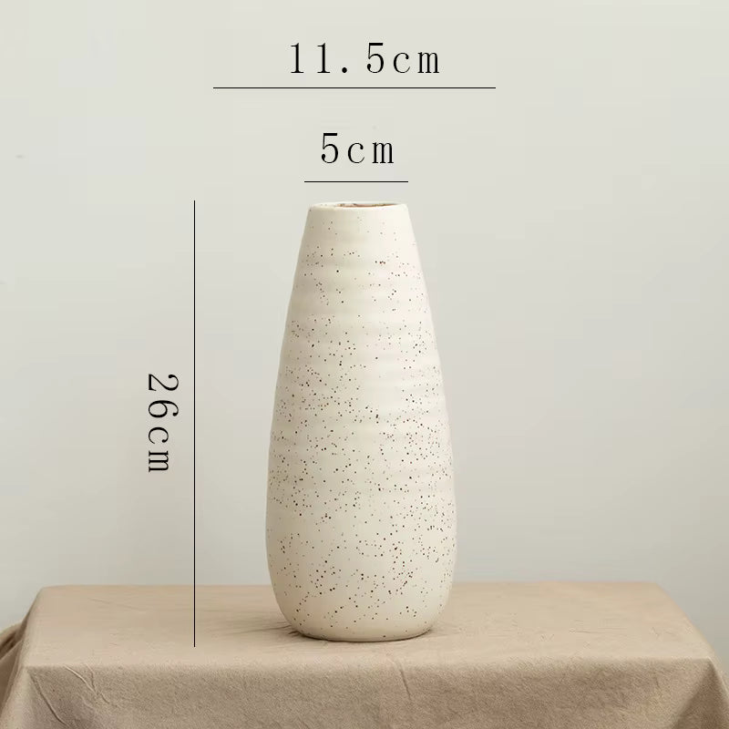 White textured vase on a beige surface with measurements indicated.
