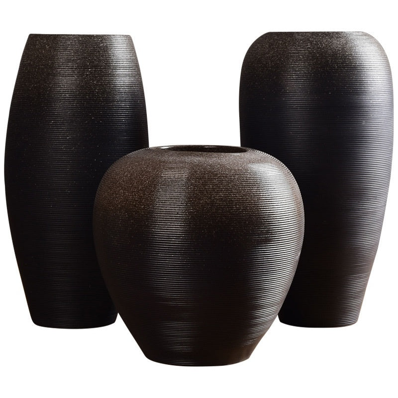Three black textured vases of different sizes on a white background