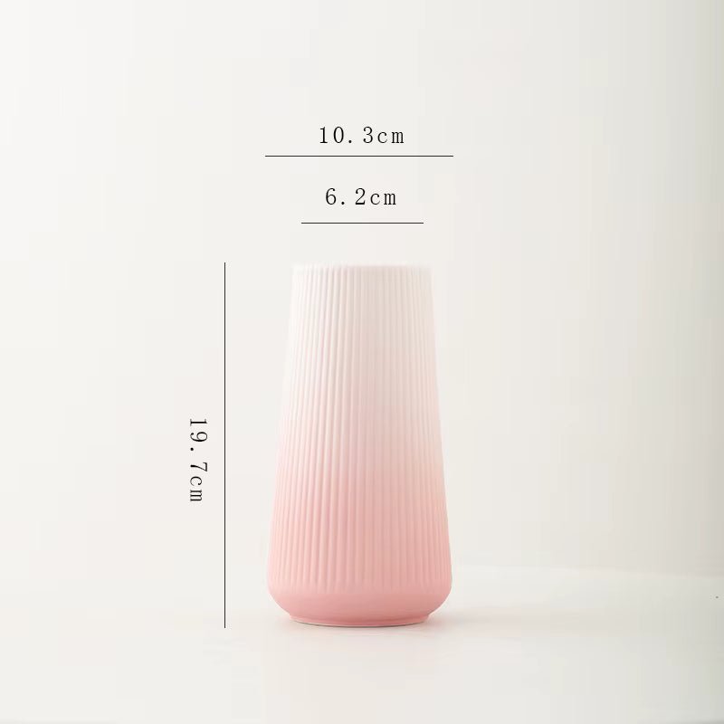 Pink ribbed vase with measurements on a white background