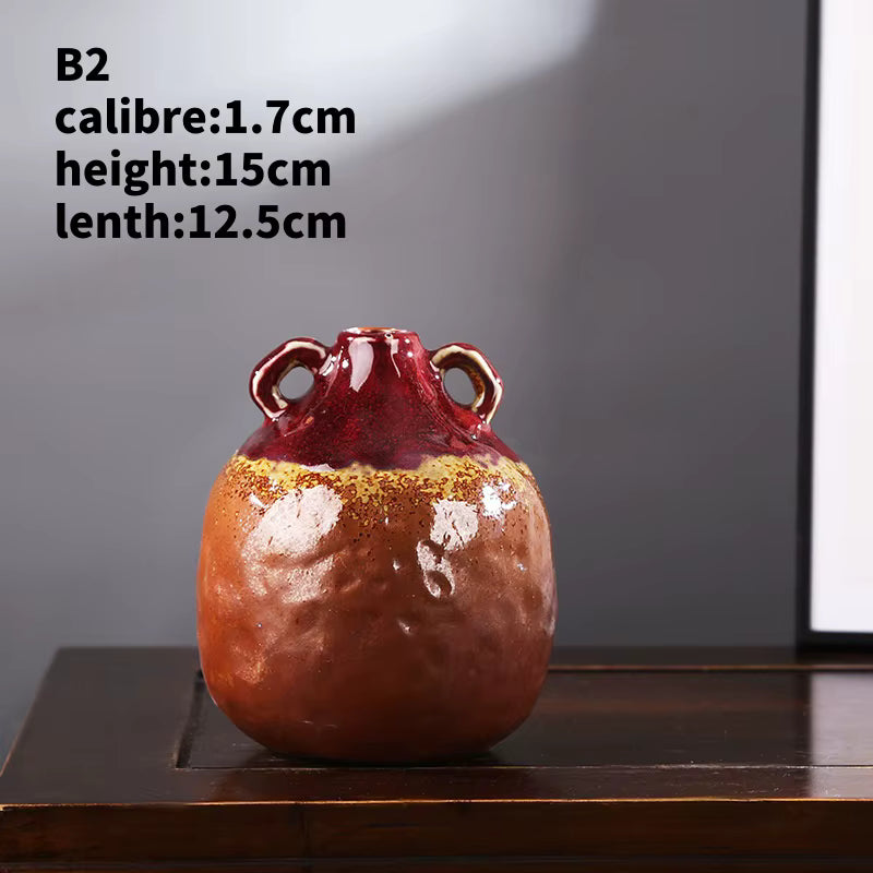 Ceramic vase with red and gold glaze on a wooden surface