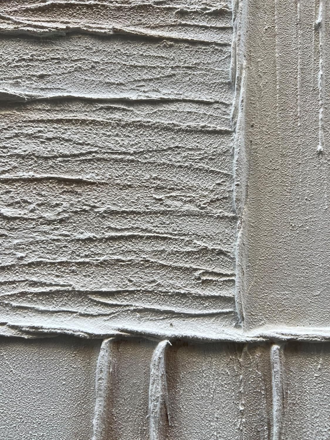 Close-up of textured concrete wall with horizontal and vertical patterns