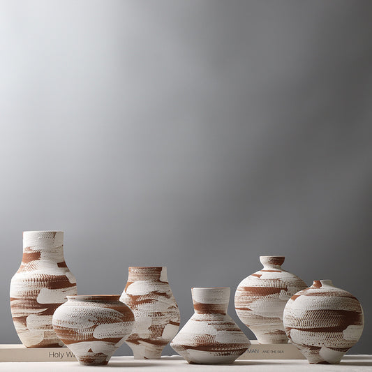 Set of ceramic vases with brown and white patterns on a gray background