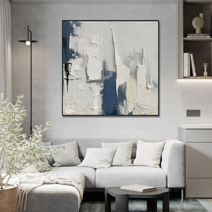 Modern living room with a gray sofa, abstract painting, and decorative items.
