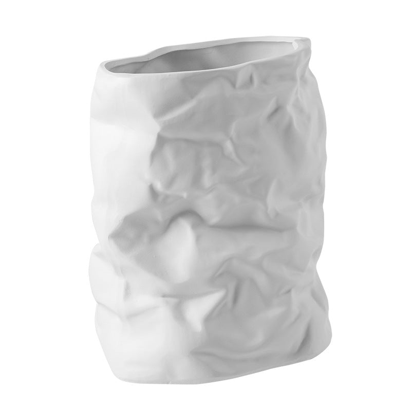 White ceramic vase with textured surface on a white background