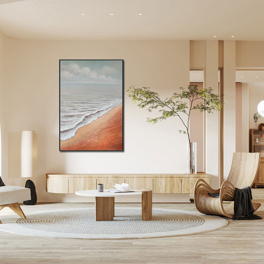 Modern living room with a beach-themed painting on the wall, wooden coffee table, and wicker chair.