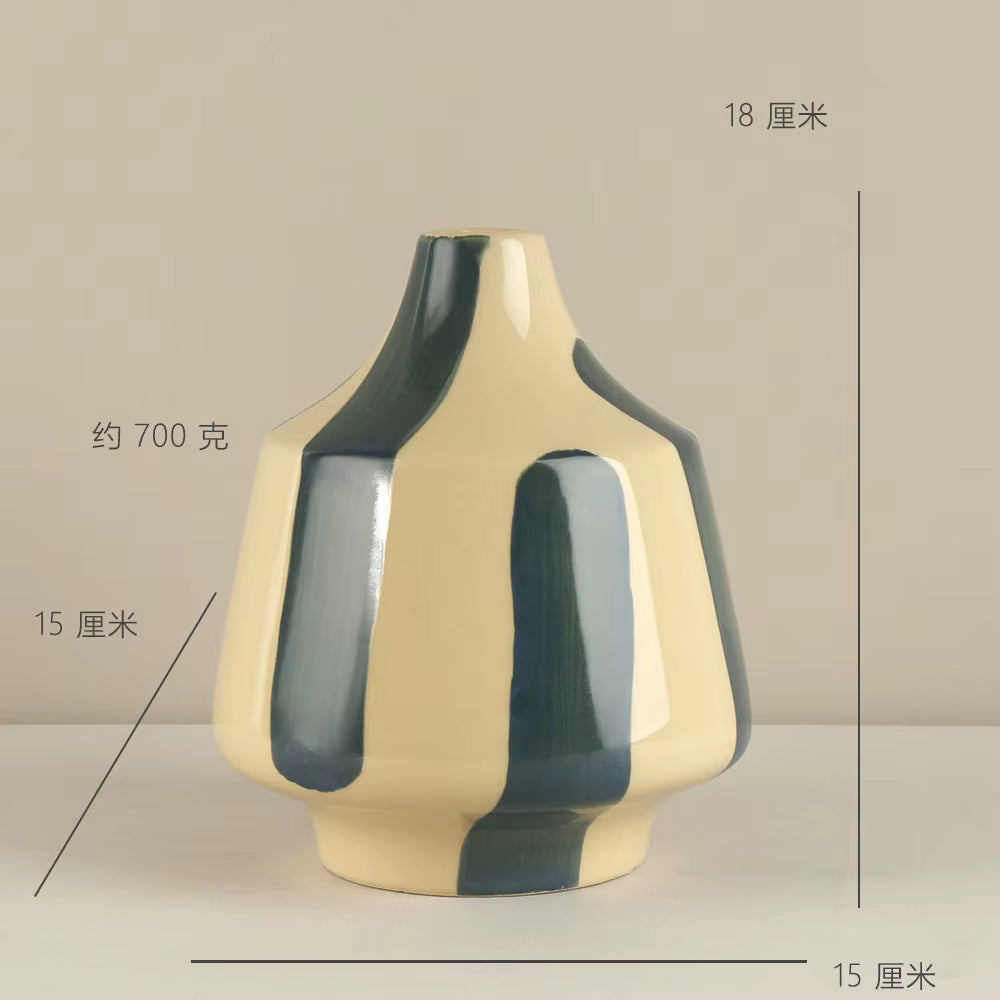 Ceramic vase with green and beige design on a neutral background
