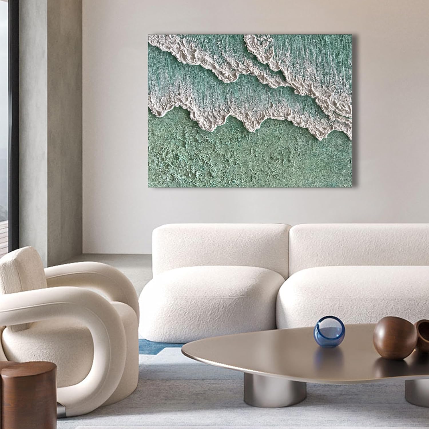 Modern living room with a white sofa, armchair, and coffee table, featuring a large abstract painting of waves on the wall.