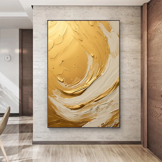 Abstract art piece with gold and beige colors on a wall in a modern interior setting.