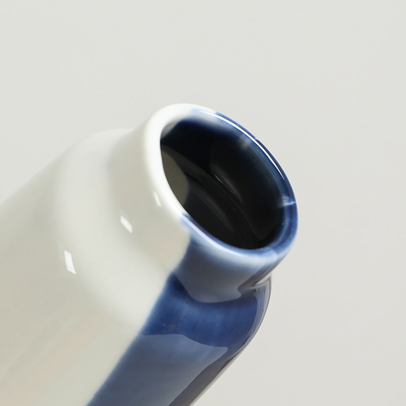 Ceramic vase with blue and white gradient on a light gray background