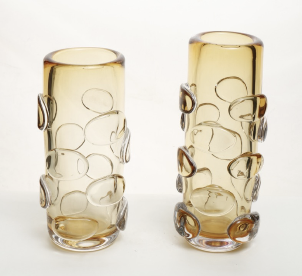 Two amber glass vases with decorative patterns on a white background