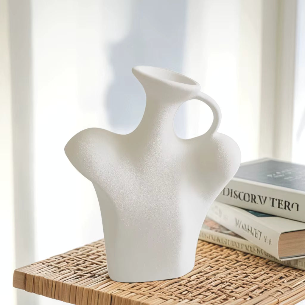 White ceramic vase on a wicker surface with books in the background