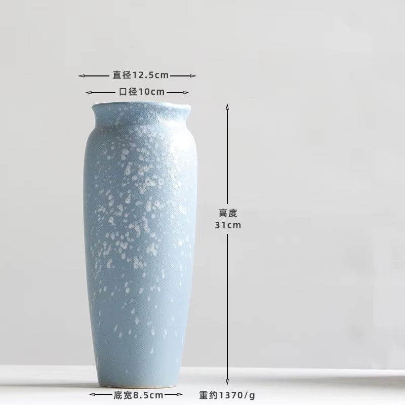 Blue ceramic vase with measurement labels on a white background