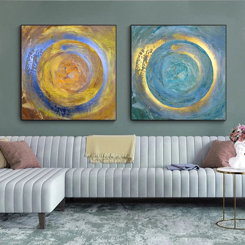 Two abstract paintings above a sofa in a living room setting.