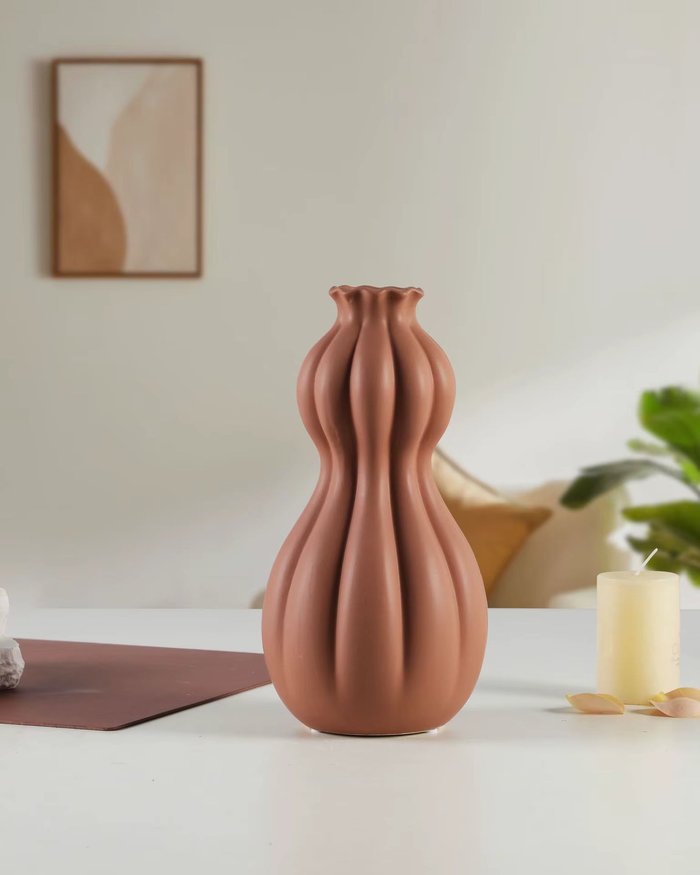 Brown textured vase on a white surface with a blurred background