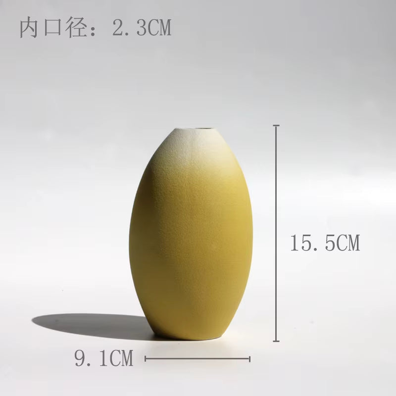 Yellow ceramic vase with measurements on a white background