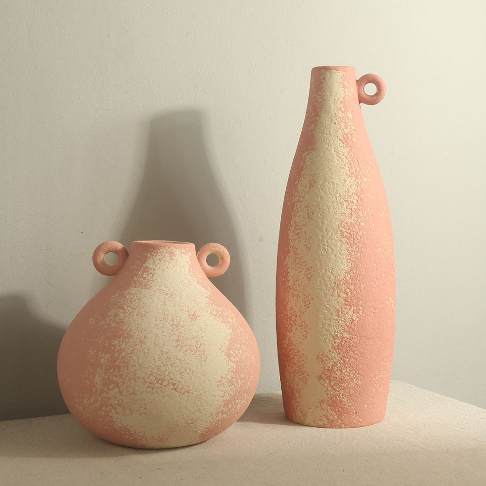 Two ceramic vases with a textured finish on a neutral background