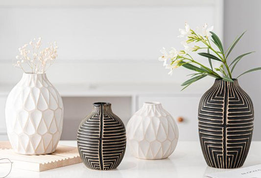 Four decorative vases with geometric patterns on a light background
