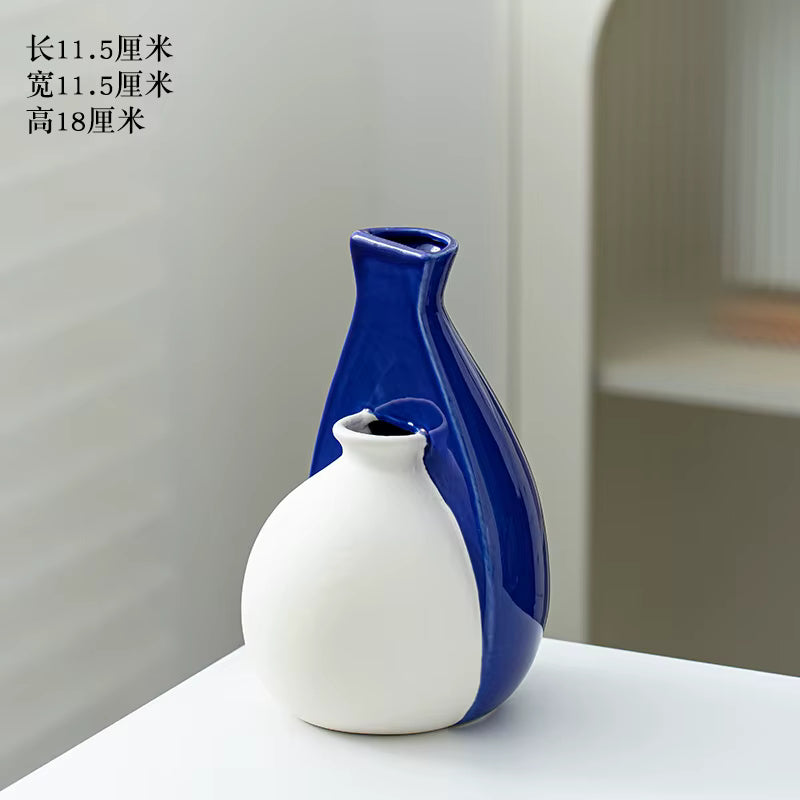 Blue and white ceramic vase on a white surface with a neutral background