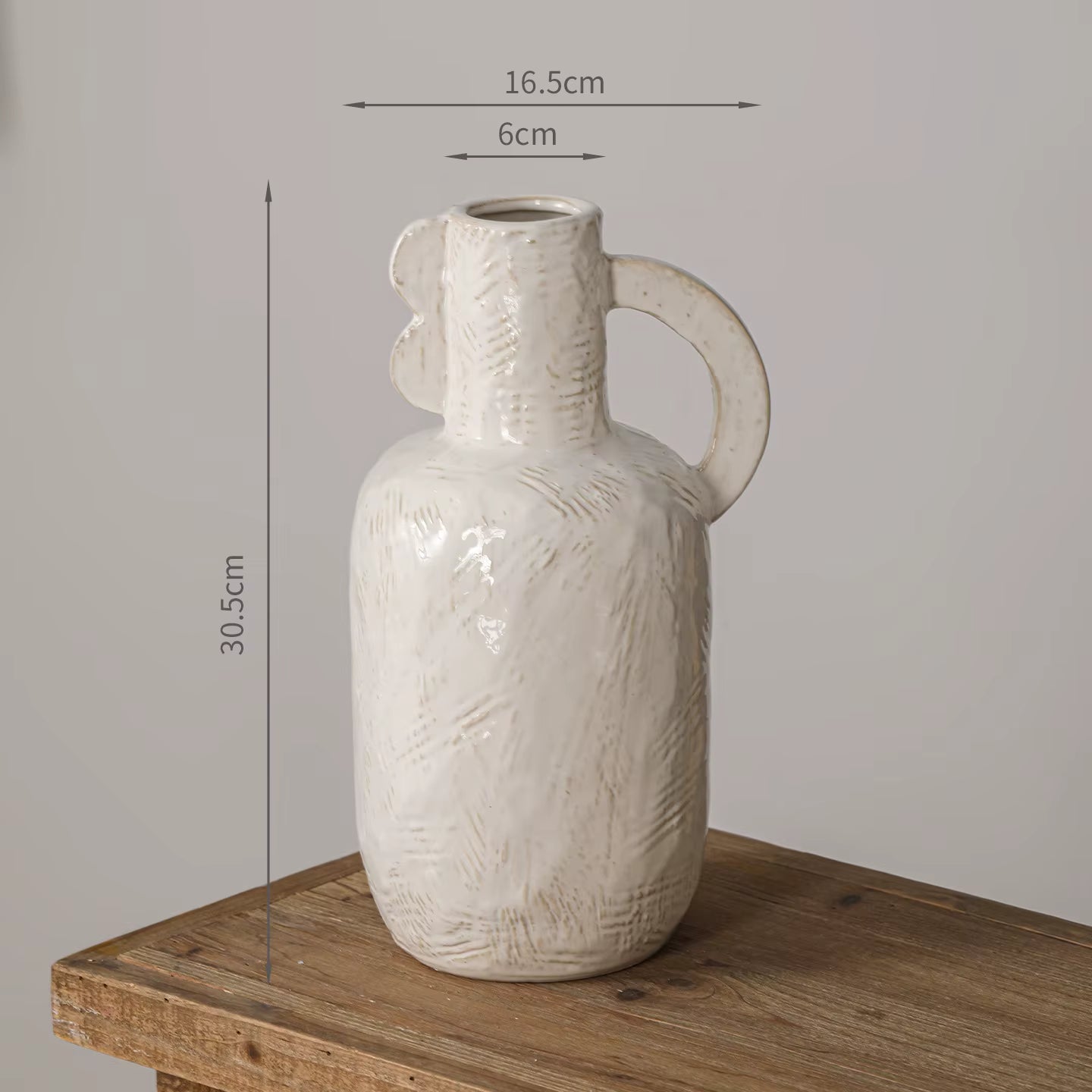 White textured vase with dimensions on a wooden surface and gray background