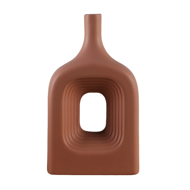 Brown ceramic vase with a unique design on a white background