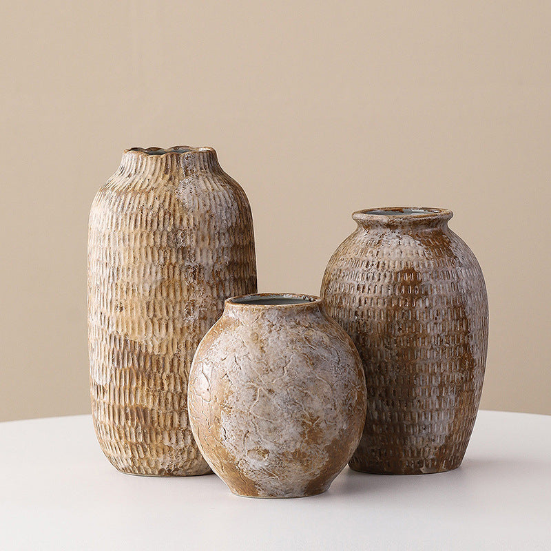 Three textured ceramic vases on a neutral background