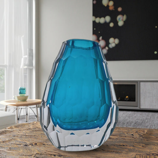 Blue glass vase on a wooden table in a living room setting