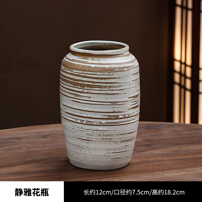 Ceramic vase with striped design on a wooden surface