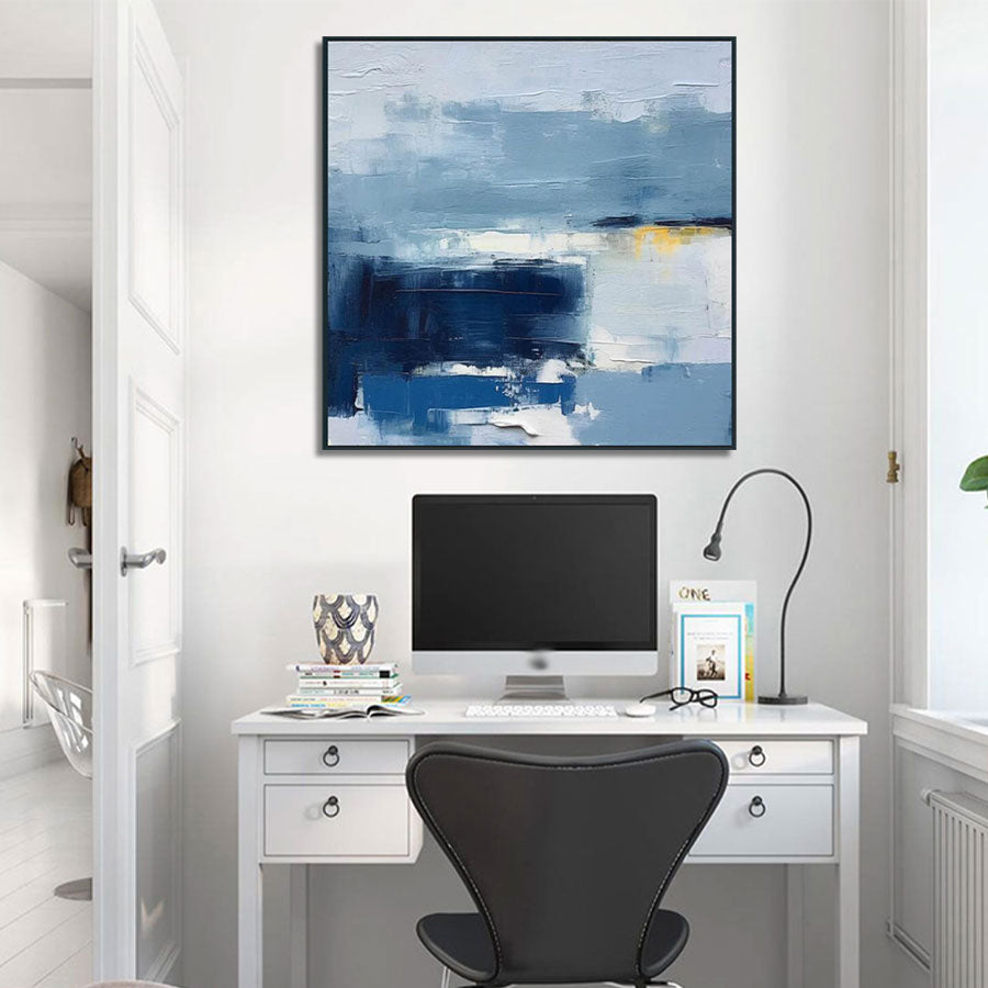 Modern home office with a desk, computer monitor, and abstract painting on the wall.