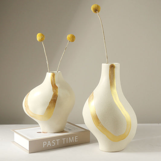 Two white vases with gold accents on a gray background