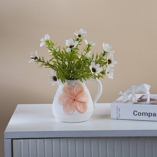 Decorative vase with floral design on a table against a beige wall