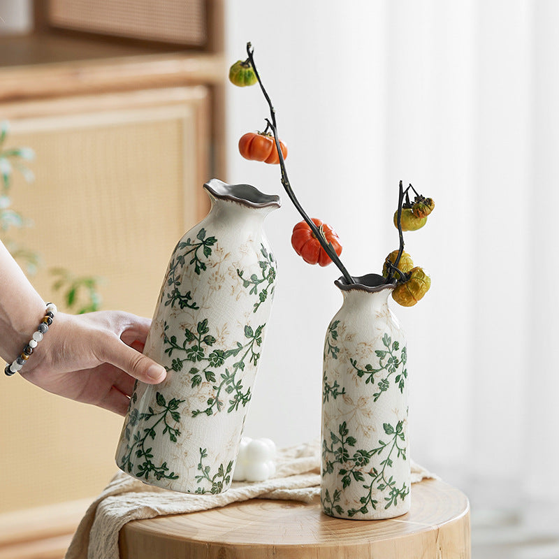 Two ceramic vases with floral patterns on a wooden surface.