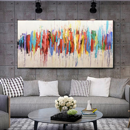 Colorful abstract painting on a gray wall above a gray sofa with decorative pillows.