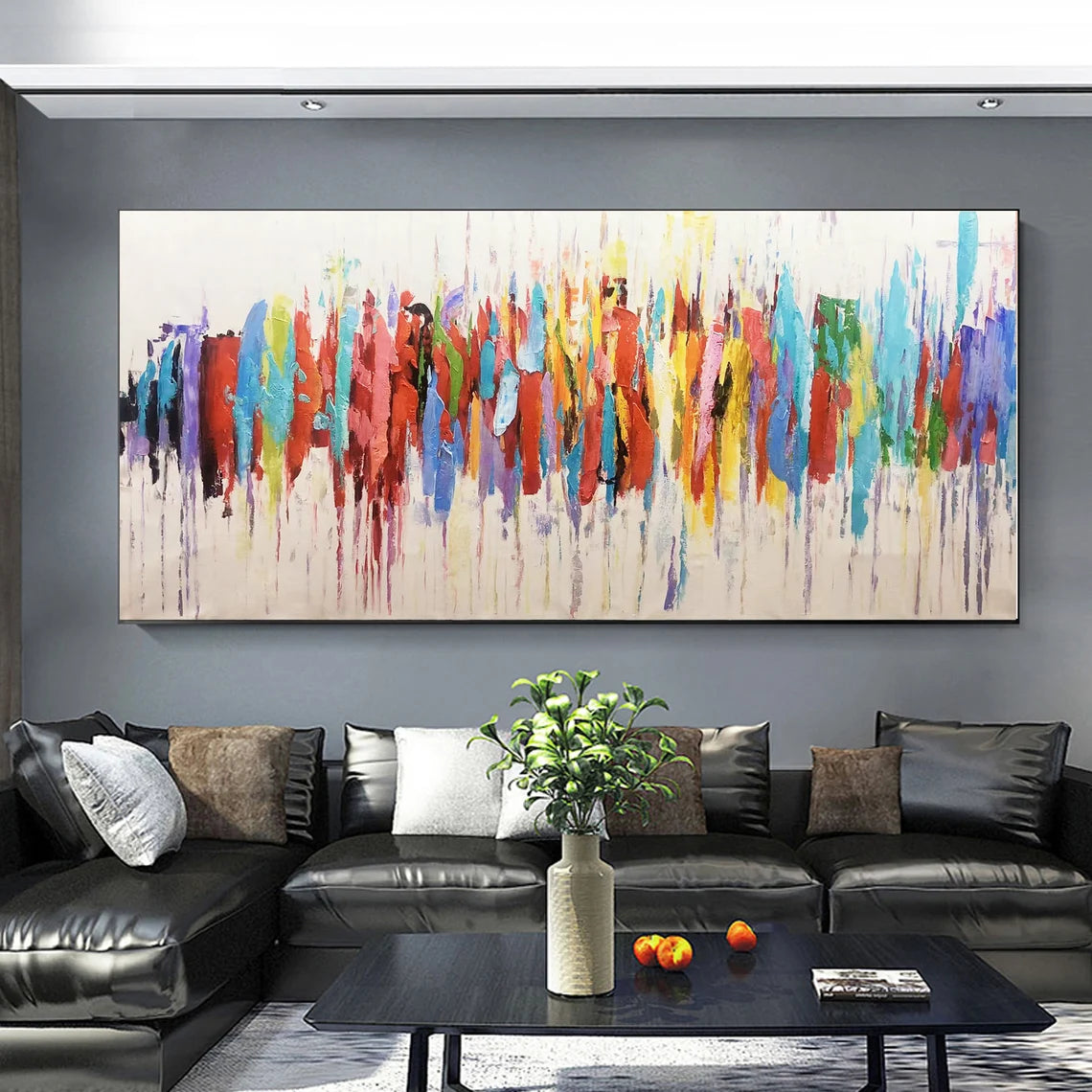 Living room with a large abstract painting on the wall above a black sofa.