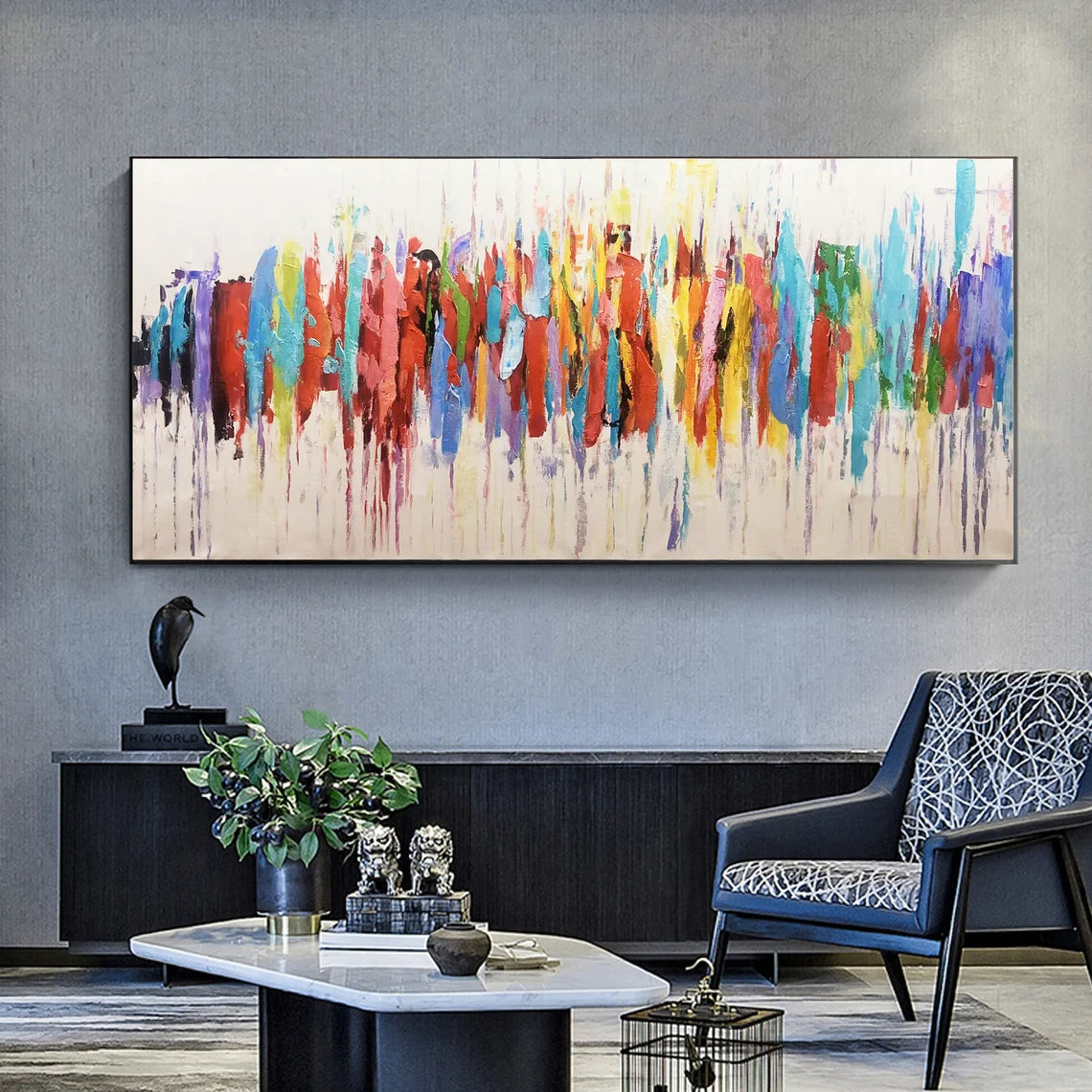 Modern living room with abstract colorful painting on the wall, blue armchair, and decorative items.