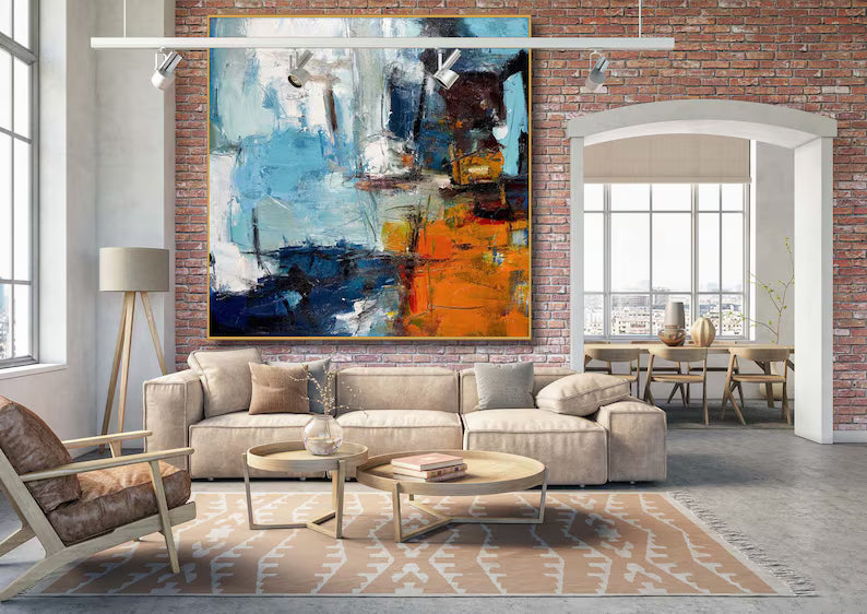 Modern living room with a large abstract painting on a brick wall.