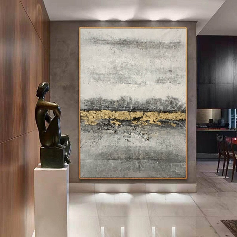 Abstract painting with gold accents on a wall in an interior setting with a sculpture.