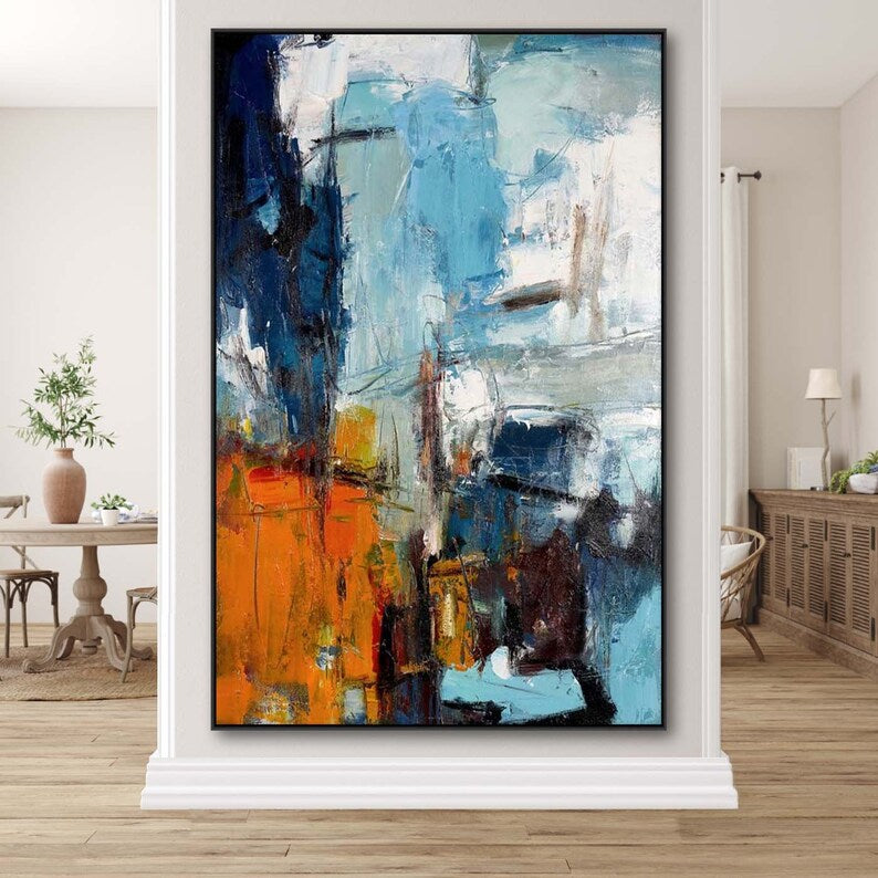 Abstract painting with blue, orange, and white colors in a modern living room setting.