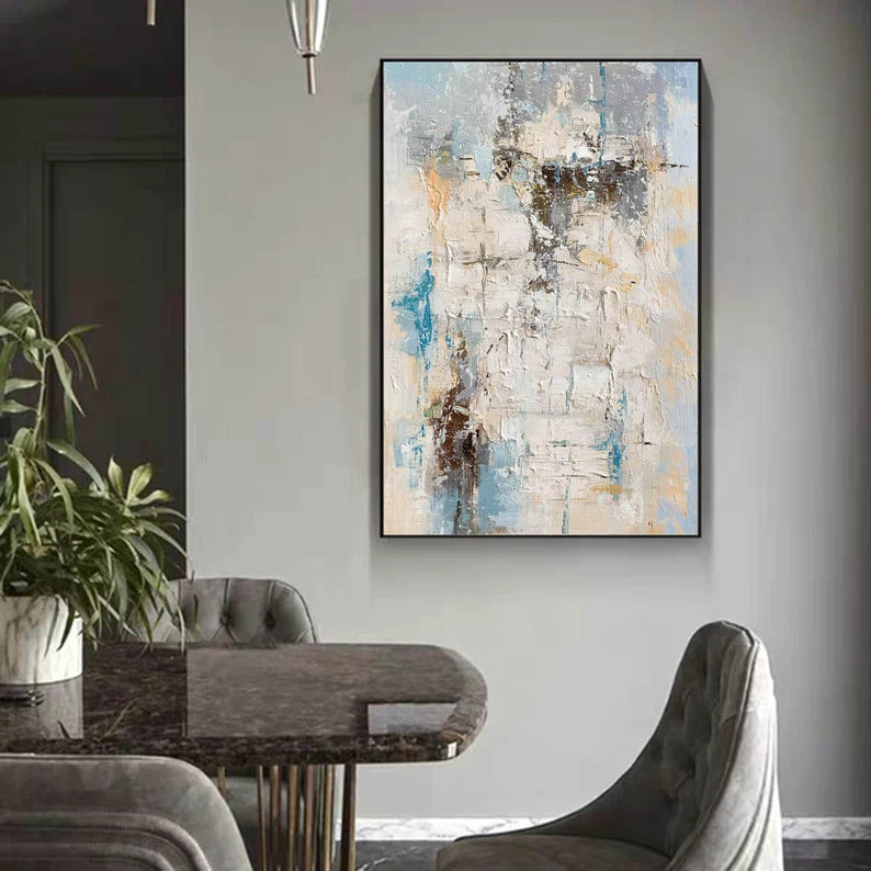 Abstract painting on a wall above a dining table with chairs