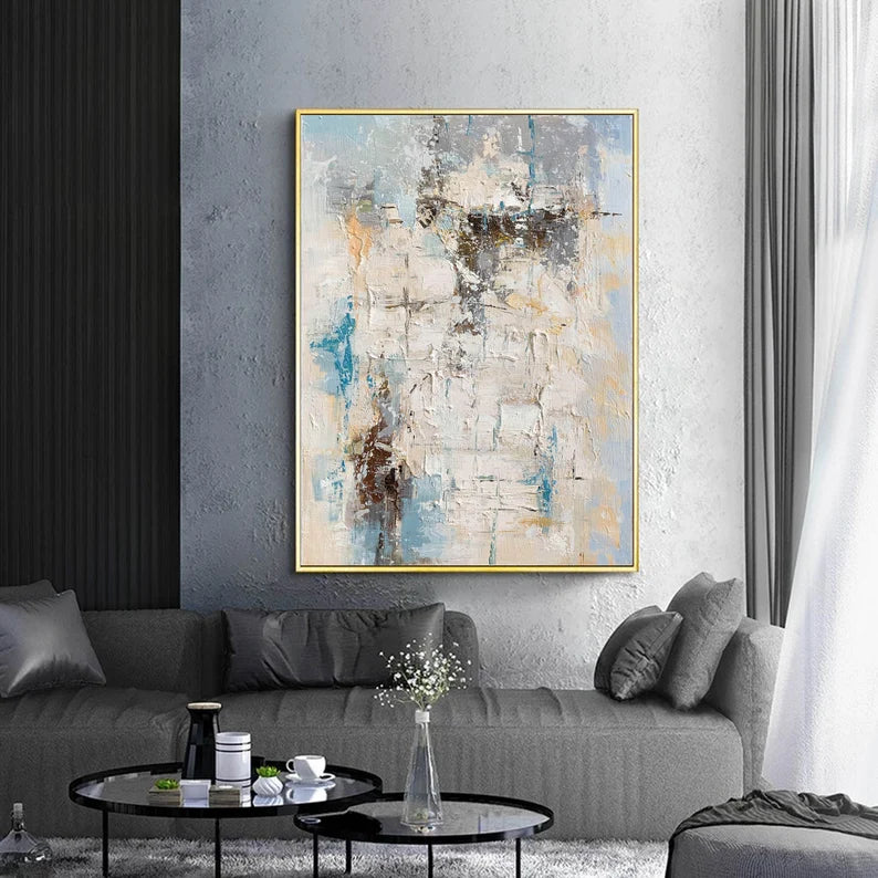 Abstract painting in a living room with a gray sofa and coffee table.
