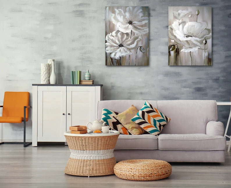 Living room with a gray sofa, wicker coffee table, and floral wall art.