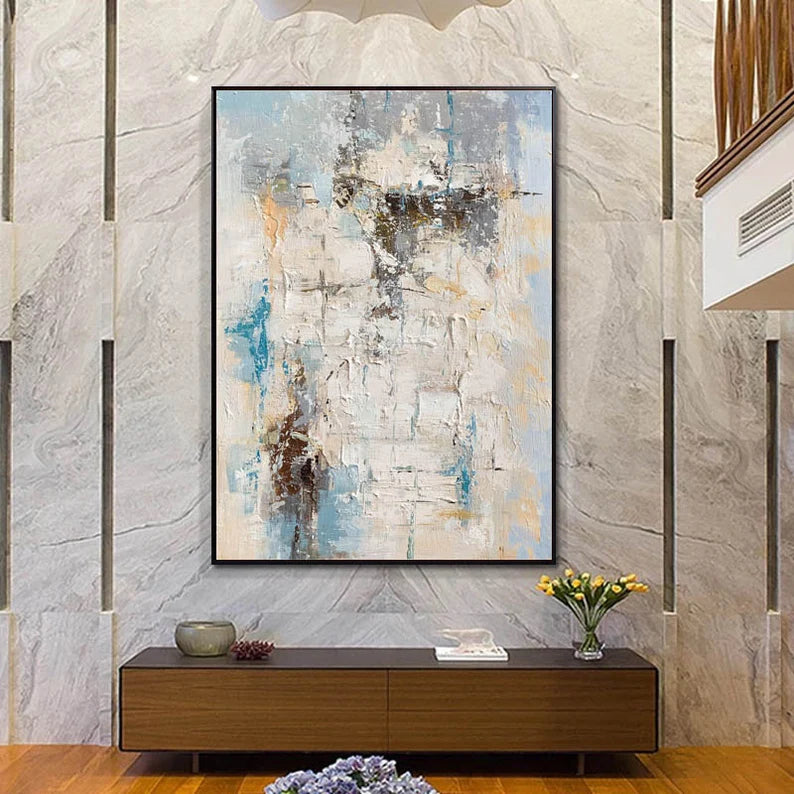 Abstract painting on a wall above a wooden console table with decorative items.