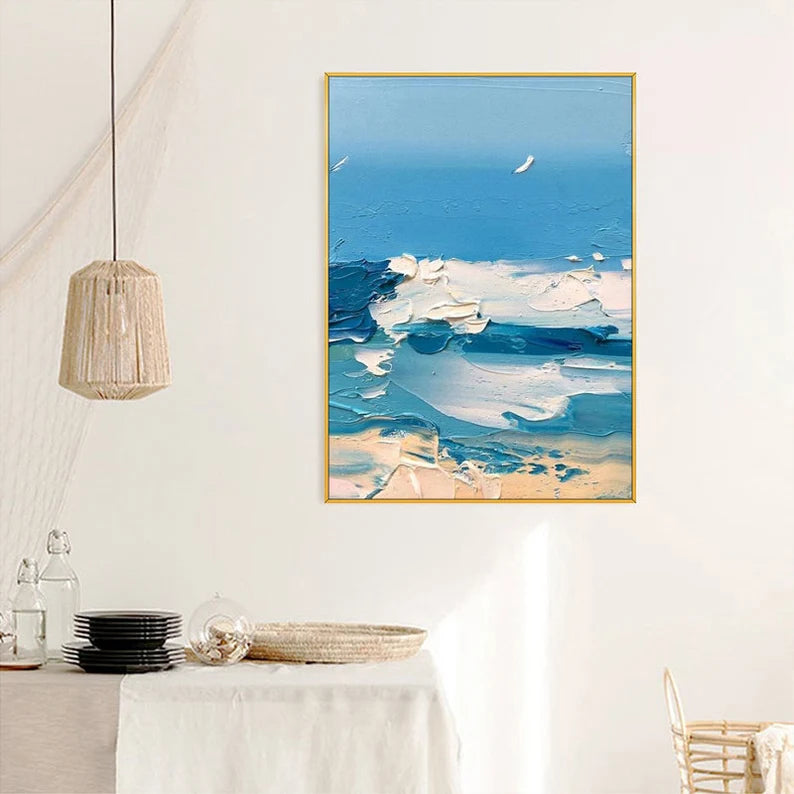Abstract painting of a blue sky with clouds in a gold frame on a white wall.