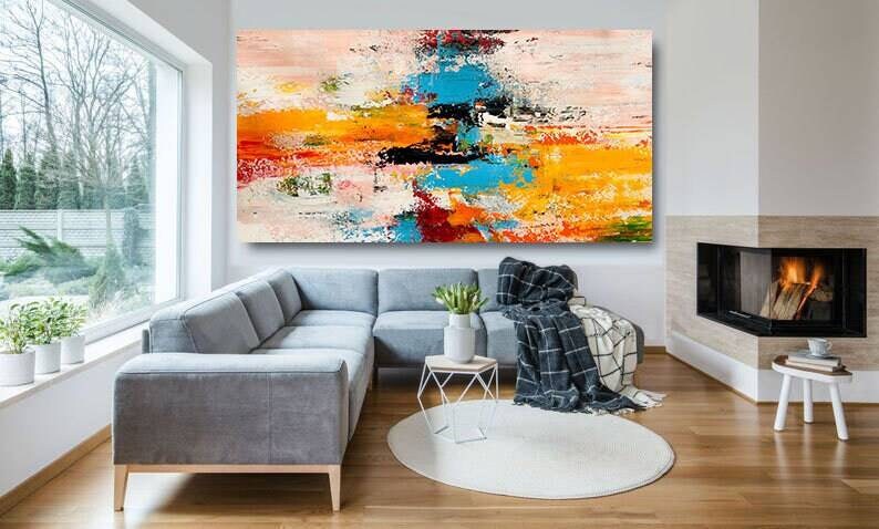 Modern living room with a gray sectional sofa, abstract painting, and fireplace.