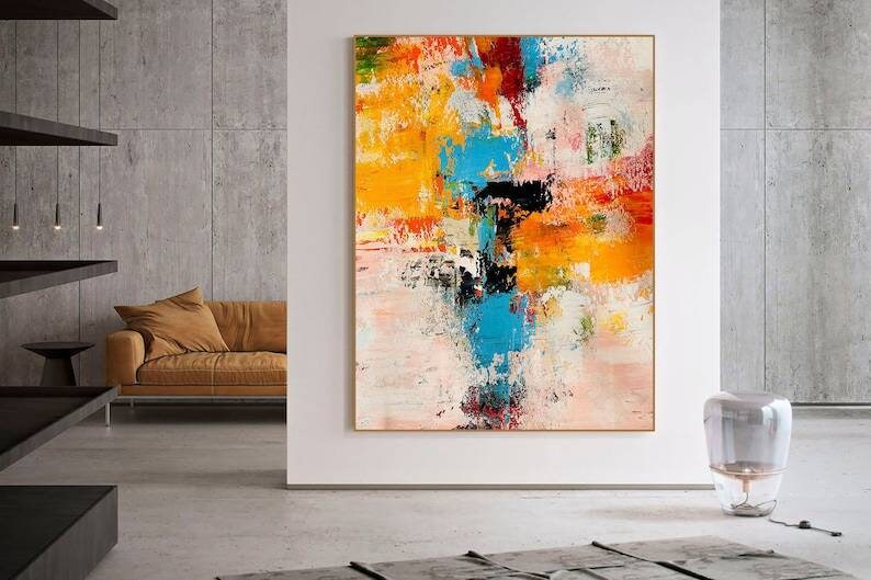 Abstract painting in a modern living room with a brown sofa and gray walls.