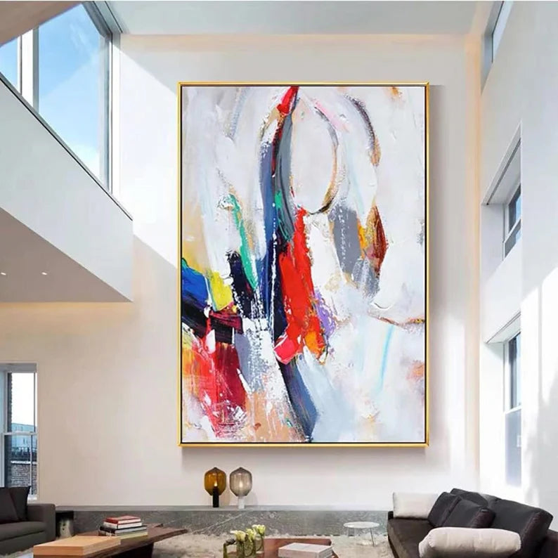 Abstract painting in a modern living room with large windows.