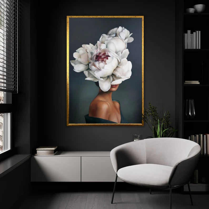 Modern interior with a large framed artwork of a woman with white flowers on her head, a gray chair, and a dark wall.