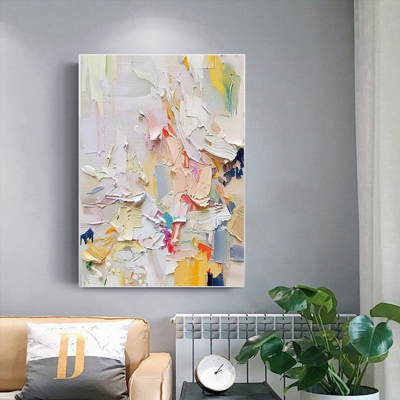 Abstract painting on a gray wall above a sofa with a plant and clock.