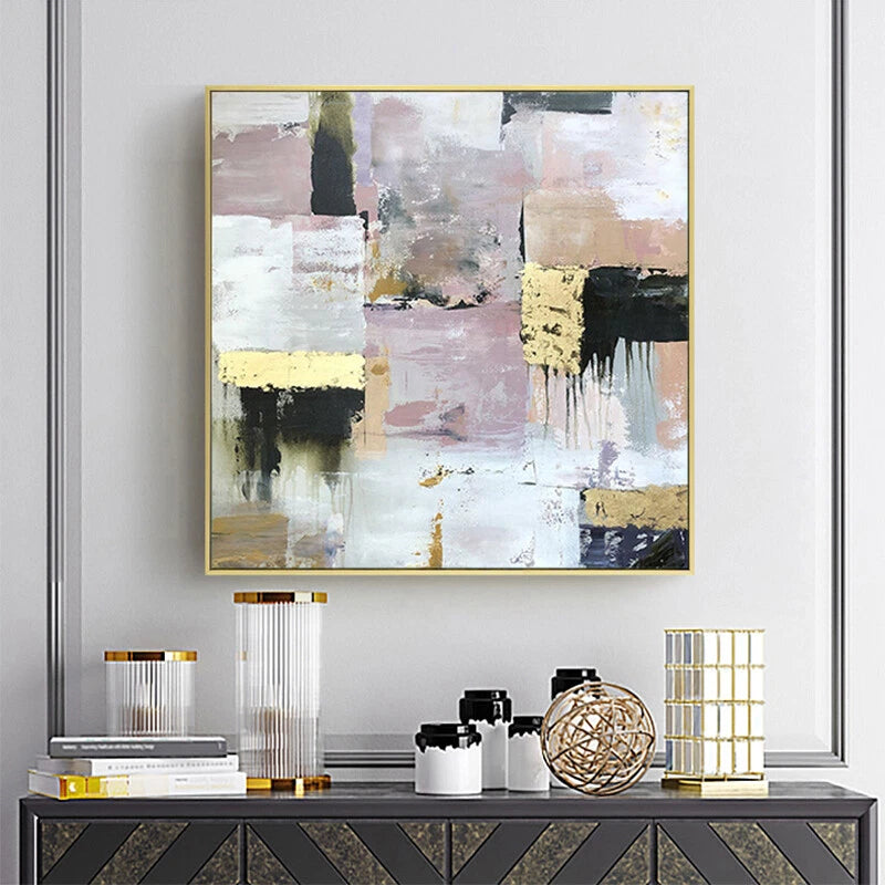 Abstract art piece on a wall above a console table with decorative items.
